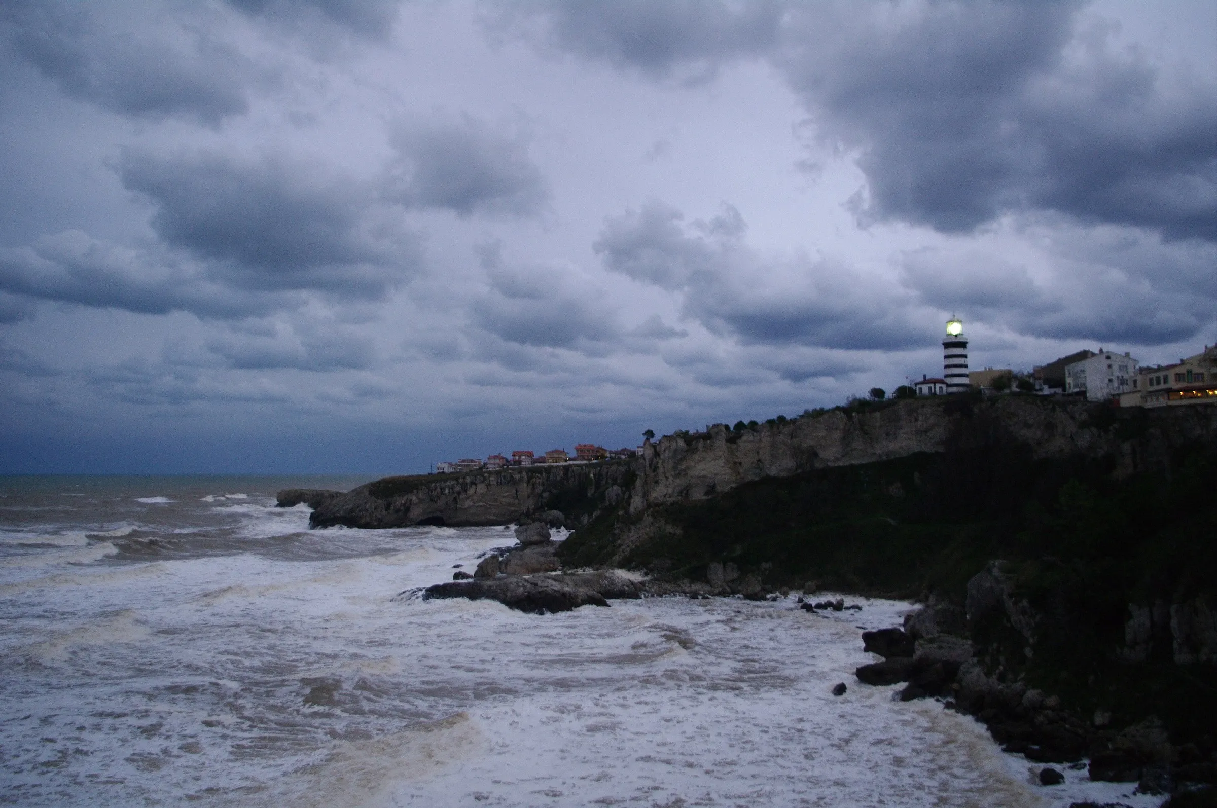 Bulutlu bir günde dalgalı deniz ve kıyıdaki kayalıklar